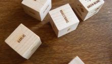 Six wooden dice with names of ingredients stamped on the faces.